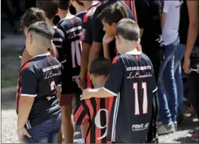  ??  ?? Children wait for soccer player Emiliano Sala’s coffin to depart for Santa Fe, after his wake in Progreso, Argentina, on Saturday. AP PHOTO/NATACHA PISARENKO