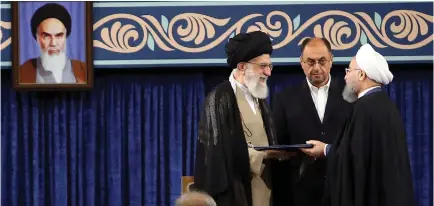  ?? (Reuters) ?? IRAN’S PRESIDENT Hassan Rouhani receives the presidenti­al mandate from Supreme Leader Ayatollah Ali Khamenei during an endorsemen­t ceremony in Tehran yesterday.