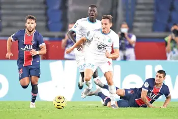  ??  ?? Thauvin (centre) runs with the ball during the French L1 football match between PSG and Marseille at the Parc de Princes stadium in Paris. - AFP photo