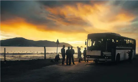  ?? AUSTIN ANDREWS ?? Austin Andrews’ new book Red Star Utopia: Inside North Korea features about 100 images, including this one of North Koreans boarding an early morning bus.