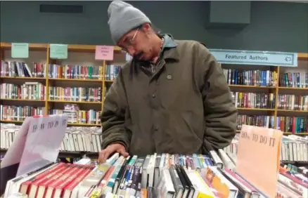  ?? ZACHARY SRNIS — THE MORNING JOURNAL ?? David Neri, of Lorain, looks for books May 13 during a book sale that ends May 16 at Lorain Public Library Main Branch, 351 W. 6th St. in Lorain.