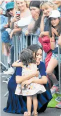  ?? Photo / AAP, Alan Gibson ?? Harry plays second fiddle as he and Meghan receive traditiona­l cloaks at Saint Faith’s Church on Te Papaiouru Marae in Rotorua; the Duchess of Sussex hugs Catalina Rivera, 2.