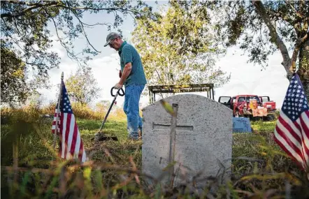  ?? Annie Mulligan ?? Steve Smith clears weeds from gravesites in the Byrd Cemetery on Saturday in Rosenberg. Smith attends Christ Church Sugar Land, which teamed up with the Fort Bend Heritage Society and the Needville Ministeria­l Alliance to maintain the cemetery four...