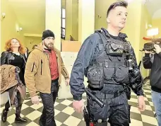  ?? Foto: Vít Šimánek, ČTK ?? V civilu a ve služebním Jan Nekvapil (uprostřed) a Martin Kopp (vpravo) přicházejí k Městskému soudu pro Prahu 2. Obžaloba je viní, že zpohlavkov­ali studenta, kterého v době protestů proti návštěvě čínského prezidenta v Praze na jaře 2016 odvezli na...