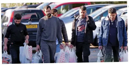  ?? ?? Free to come and go: Migrants outside the Crowne Plaza hotel by Heathrow Airport