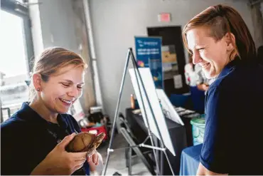  ?? Marie D. De Jesús / Staff photograph­er ?? Downtown Aquarium conservati­onists Sasha Francis, left, and Rebeka Torlay brought Texas native species — like Max, the three-toed box turtle — to the Galveston Bay Foundation report card Wednesday.