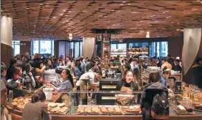  ?? GAO ERQIANG / CHINA DAILY ?? Customers select beverages and food items at the Starbucks Reserve Roastery in Shanghai. The store, which covers 2,700 square meters, is its largest outlet in the world.