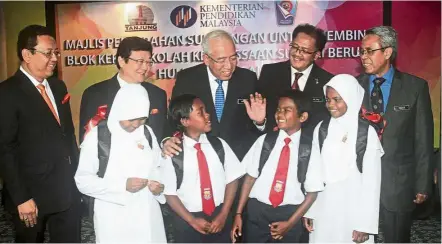  ??  ?? Mahdzir (third from left, second row) speaks to SK Sungai Berua pupils (from left, front row) Samira Dolah, Fadhli Alias, Izwan Daud and Rosnorlia Musaidi at the ceremony. Looking on (from left, second row) are Dr Nik Nozrul Thani, Tan, Alias and Dr...