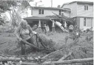  ?? WAYNE CUDDINGTON / POSTMEDIA NEWS ?? Volunteers, including Peggis Slavin, came to help clear debris from Tracey Graham’s Ottawa home.