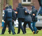  ?? MICHAEL PROBST/AP ?? German police bring in a suspect, second from right, for questionin­g Wednesday in Karlsruhe, a city of 300,000 about 50 miles northwest of Stuttgart.