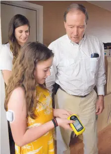  ?? GREG SORBER/JOURNAL ?? Gabby Arias, 11, discusses her insulin management system with U.S. Sen. Tom Udall during his visit to her Rio Rancho home.