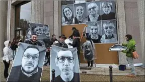  ??  ?? Des membres de la convention accrochent leur portrait à Paris, le 5 mars.