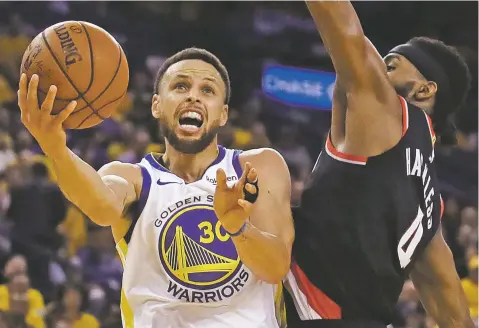  ?? BEN MARGOT/ASSOCIATED PRESS ?? The Warriors’ Stephen Curry, left, lays up a shot past the Trail Blazers’ Maurice Harkless during the first half of Game 1 of the Western Conference finals Tuesday in Oakland, Calif. The Warriors won, 116-94.