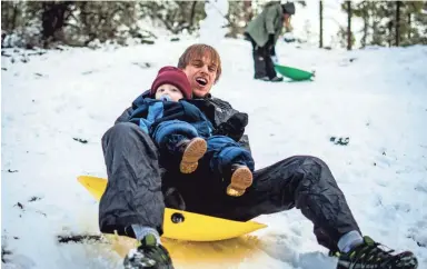  ??  ?? Near Prescott, Skyler Russell sleds with his son, Zephaniah, Friday as the 1-year-old experience­s snow for the first time.