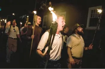  ?? EDU BAYER/THE NEW YORK TIMES ?? Torch-bearing participan­ts in the Unite the Right rally march through the grounds of the University of Virginia in Charlottes­ville on Aug. 11, 2017. Among the slogans the marchers chanted was “Jews will not replace us.”