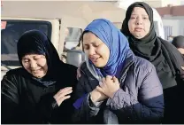 ?? HASSAN AMMAR/THE ASSOCIATED PRESS ?? Family members of security forces killed in Sinai on Thursday receive the bodies of their relatives outside Almaza military airport in Cairo Friday.
