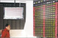 ?? Associated Press ?? An investor looks at a stock price display screen at a brokerage house in Shanghai on Friday.