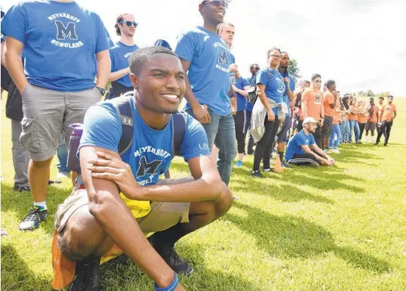  ?? ALGERINA PERNA/BALTIMORE SUN PHOTOS ?? Adrian Davey watches fellow Meyerhoff Scholars take part in competitio­ns during the Welcome Back Family Meeting/Picnic held at Centennial Park East.