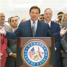  ?? WILFREDO LEE/AP ?? Gov. Ron DeSantis speaks surrounded by supportive lawmakers in 2021. Florida is one of 40 states where one party controls the governorsh­ip and entire legislatur­e.