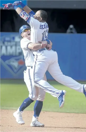  ?? FRED THORNHILL/THE CANADIAN PRESS ?? Toronto’s Edwin Encarnacio­n jumps into the arms of teammate Josh Donaldson after droving in the winning run in the ninth inning Sunday as the Blue Jays beat the Yankees 4-3.