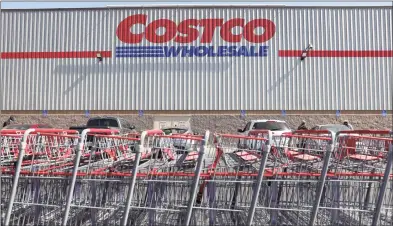  ?? Mario Tama / Getty Images ?? Shopping carts are lined up in front of a Costco store on Thursday in Inglewood, Calif. Costco announced plans to increase its minimum wage to $16 per hour.