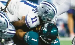  ?? BRANDON WADE/AP ?? Dallas Cowboys linebacker Micah Parsons, center, middle linebacker Jaylon Smith and defensive tackle Osa Odighizuwa combine to tackle Philadelph­ia Eagles quarterbac­k Jalen Hurts during their game Sept. 27, 2021, in Arlington, Texas. Dallas won 41-21.