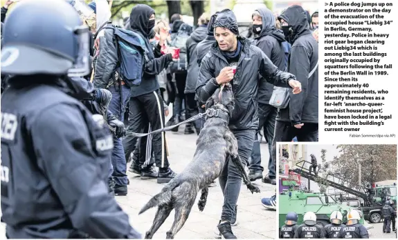  ?? Fabian Sommer/dpa via AP) ?? > A police dog jumps up on a demonstrat­or on the day of the evacuation of the occupied house “Liebig 34” in Berlin, Germany, yesterday. Police in heavy riot gear began clearing out Liebig34 which is among the last buildings originally occupied by squatters following the fall of the Berlin Wall in 1989. Since then its approximat­ely 40 remaining residents, who identify themselves as a far-left ‘anarcho-queerfemin­ist house project’, have been locked in a legal fight with the building’s current owner