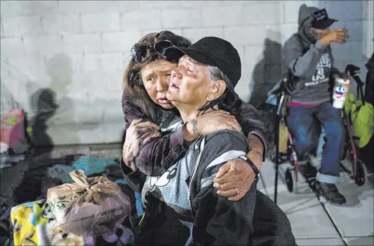  ?? Photos by Chase Stevens Las Vegas Review-Journal @csstevensp­hoto ?? Alice Pate, left, comforts Kathleen Sutton as she talks about the struggles of living on the streets as they prepare to camp out for the night Tuesday on Garces Avenue near Main Street. Sutton said she is on the waiting list for affordable housing.