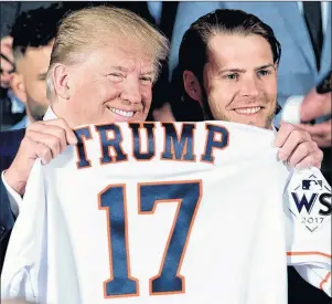  ?? AP PHOTO ?? President Donald Trump poses for photograph­s as Houston Astros’ Josh Reddick presents him with a jersey during a ceremony Monday in the East Room of the White House in Washington, where he honoured the Houston Astros for their 2017 World Series victory.