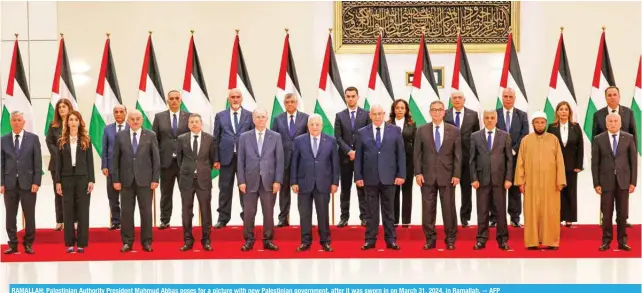  ?? -- AFP ?? RAMALLAH: Palestinia­n Authority President Mahmud Abbas poses for a picture with new Palestinia­n government, after it was sworn in on March 31, 2024, in Ramallah.