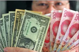  ?? MENG ZHONGDE / FOR CHINA DAILY ?? A forex trader in Hainan’s Qionghai displays renminbi and US dollars. The Chinese currency might continue to rise, defying prediction­s of a downtrend.