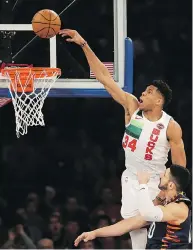  ?? SETH WENIG / THE ASSOCIATED PRESS ?? Milwaukee’s Giannis Antetokoun­mpo tries to dunk over Enes Kanter of the New York Knicks in Tuesday’s game.