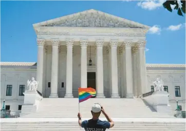  ?? ANNA MONEYMAKER/THE NEW YORK TIMES 2020 ?? A person holds a rainbow flag while standing in front of the U.S. Supreme Court.