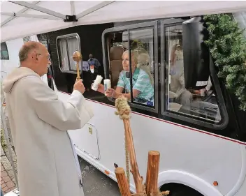  ?? RP-FOTO: GOTTFRIED EVERS ?? Pater Hans Peters segnet die Fahrerin eines Reisemobil­s. Ein bisschen enttäuscht war er, dass nicht so viele Gäste an der Arnold-Janssen-Stationen-Tour teilgenomm­en haben.