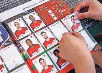  ?? FOTO: DPA ?? Es wird wieder eifrig gesammelt und geklebt – die Deutschen lieben die Panini-Fußballbil­der. Um ein Album zu komplettie­ren, muss ein Sammler laut einer Berechnung 967 Panini-Tüten kaufen und rund 870 Euro ausgeben.