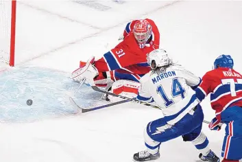  ?? PAUL CHIASSON/ASSOCIATED PRESS ?? Tampa Bay’s Pat Maroon slips the puck past Montreal goaltender Carey Price to tie Monday’s Game Four of the Stanley Cup final in the third period. But the Canadiens won in overtime, 3-2.