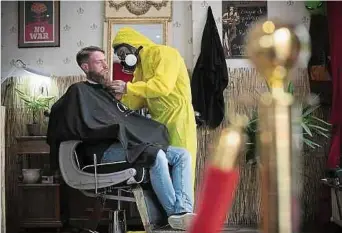  ?? Fotos: Guy Wolff ?? Momentan arbeitet Marc Weisen in seinem Herrensalo­n aufgrund des Coronaanst­eckungsris­ikos in einem gelben Overall und mit Gasmaske. Natürlich sei das Ganze auch Entertainm­ent, gibt er unumwunden zu.