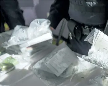  ?? ERNEST DOROSZUK/POSTMEDIA NETWORK ?? OPP Sgt. Peter Leon holds seized bags of fentanyl on display at a press conference at a hotel in Vaughan, Ont., last week. In an effort to get the deadly opioid fentanyl off the streets, certain Crime Stoppers organizati­ons in Ontario are offering a...