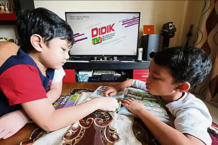  ?? - Bernama ?? Home-based learning: Muhammad Afif Darwish Mohd Rashdan, 7, (left) with his brother Muhammad Alif Daniel Mohd Rashdan, 9, getting ready to tune in to DidikTV.