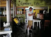  ?? Kin Man Hui / Staff photograph­er ?? Nate Brown walks assesses the damage to Comfort Cafe after it flooded during Tuesday’s heavy rains.