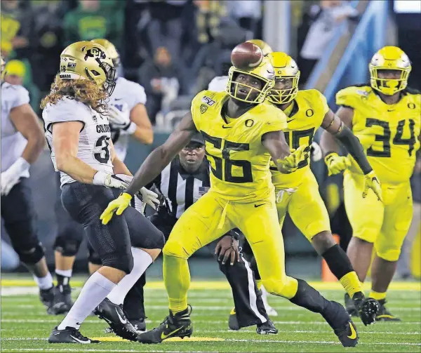  ?? [ASSOCIATED PRESS FILE PHOTOS] ?? Oregon’s Bryson Young, center, intercepts a pass intended for Colorado’s Brady Russell, left, during last Friday’s game in Eugene, Ore.