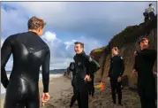  ?? ?? Luke Polonchek, center, talks with fellow lifeguards after all of them completed their 1,000-yard ocean swim in 20 minutes or less as part of their annual requalific­ation.