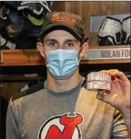  ??  ?? New Jersey Devils forward Nolan Foote shows off souvenir pucks from his first NHL game on Sunday.