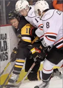  ?? CATHIE COWARD, THE HAMILTON SPECTATOR ?? Bulldogs’ Brandon Saigeon feels the squeeze from Owen Sound behind the net as 8,396 Catholic elementary school students took in Wednesday’s game.