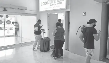  ?? PHOTOS BY DAWN GILBERTSON/ USA TODAY ?? Travelers wait in line for a COVID- 19 test at Cancun Internatio­nal Airport.