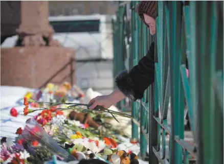  ?? DMITRI LOVETSKY ASSOCIATED PRESS ?? À Saint-Pétersbour­g, une femme dépose des fleurs au pied de la colonne d’Alexandre à la place du Palais pour rendre hommage aux victimes de l’incendie, comme tant d’autres avant elle.