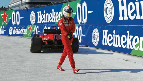  ?? Foto: Angela Baldo, dpa ?? Nachdem Sebastian Vettel seinen defekten Ferrari in Sotschi abgestellt hatte, ging er zu Fuß in die Garage zurück.