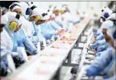  ??  ?? Brazilian employees packing meat at the Brazilian meatpacker JBS in Lapa.