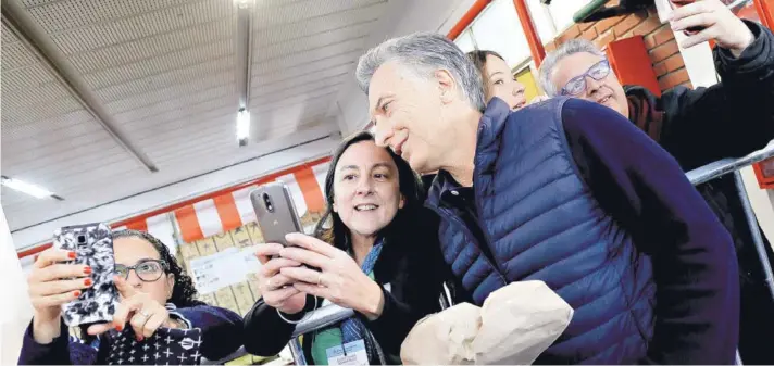  ??  ?? ► El Presidente argentino Mauricio Macri se toma una selfie en su local de votación, el domingo en Buenos Aires.