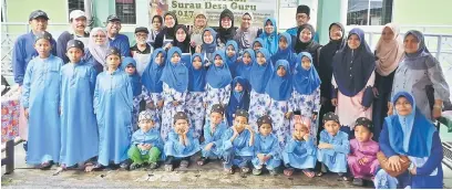  ??  ?? ALBUM: Fatimah bergambar bersama komuniti Desa Guru serta kanak-kanak dari Pertubuhan Kebajikan dan Pendidikan Sri Murni pada majlis pengagihan daging korban di Surau Al-Mualimin, Desa Guru, di Kuching, semalam.